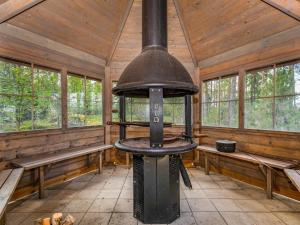 una cabaña de madera con vistas interiores a una estufa en Holiday Home Kaarna by Interhome, en Pertunmaa
