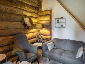 ein Wohnzimmer mit einem Sofa und einer Holzwand in der Unterkunft Holiday Home Kelorakka lodge by Interhome in Sirkka