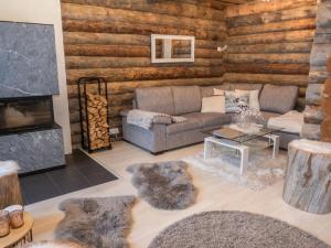 ein Wohnzimmer mit Couch und Kamin in der Unterkunft Holiday Home Salmikangas f1 by Interhome in Ruka