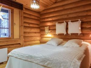 a bedroom with a bed in a wooden wall at Holiday Home Pasyni by Interhome in Sirkka