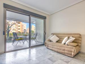 - un salon avec un canapé et une porte coulissante en verre dans l'établissement Apartment Zephyrus by Interhome, à Dénia