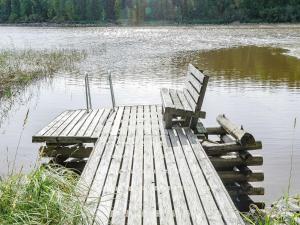 un banco sentado en un muelle en un lago en Holiday Home Haapalehto by Interhome, en Nurmes