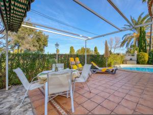 een patio met een tafel en stoelen en een zwembad bij Holiday Home Golf Y Playa by Interhome in Oliva