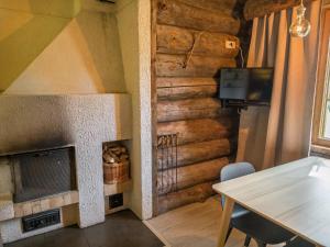 ein Wohnzimmer mit einem Kamin und einem Tisch in der Unterkunft Holiday Home Kelorakka lodge by Interhome in Sirkka