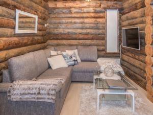 ein Wohnzimmer mit einem Sofa in einem Blockhaus in der Unterkunft Holiday Home Salmikangas f1 by Interhome in Ruka