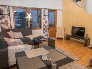un soggiorno con divano e TV di Holiday Home Karhunvartijan linna c24 by Interhome a Ruka