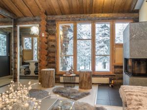 ein Wohnzimmer mit einem Blockhaus und einem großen Fenster in der Unterkunft Holiday Home Salmikangas f1 by Interhome in Ruka