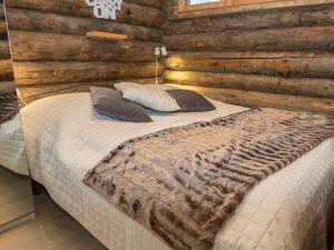ein Schlafzimmer mit einem Bett in einer Blockhütte in der Unterkunft Holiday Home Salmikangas f1 by Interhome in Ruka + 9 Fotos