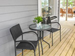 einen Glastisch und zwei Stühle auf einer Veranda in der Unterkunft Holiday Home Kaisla by Interhome in Pertunmaa