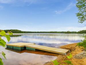 a dock in the middle of a lake at Holiday Home Kielo by Interhome in Pertunmaa
