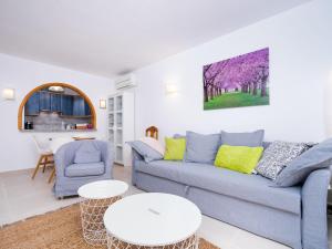 ein Wohnzimmer mit einer blauen Couch und einem Tisch in der Unterkunft Apartment Pueblo Panorama-1 by Interhome in Benitatxell