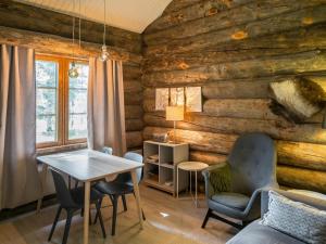 ein Wohnzimmer mit Holzwänden sowie einem Tisch und Stühlen in der Unterkunft Holiday Home Kelorakka lodge by Interhome in Levi