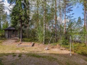 un parque infantil en el bosque con un columpio en Holiday Home Kaarna by Interhome, en Pertunmaa