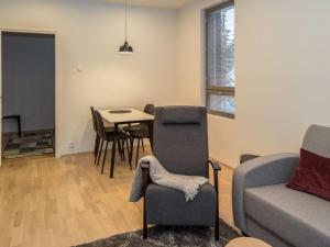 uma sala de estar com um sofá, uma mesa e cadeiras em Holiday Home Ylälänsi 3 as 11 by Interhome em Ylläsjärvi