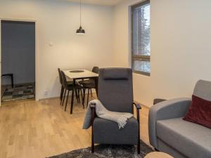 ein Wohnzimmer mit einer Couch und einem Tisch und Stühlen in der Unterkunft Holiday Home Ylälänsi 3 as 11 by Interhome in Ylläsjärvi