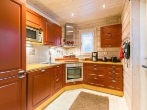 una pequeña cocina con armarios de madera y fregadero en Holiday Home Akavilla 2 by Interhome, en Jämsä