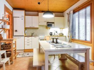 una cucina con armadi bianchi e tavolo bianco di Holiday Home Rome 10 by Interhome a Syöte