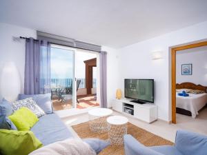 ein Wohnzimmer mit einer blauen Couch und einem Fernseher in der Unterkunft Apartment Pueblo Panorama-1 by Interhome in Benitatxell