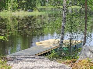 a wooden dock in the middle of a lake at Holiday Home Kurki by Interhome in Pertunmaa