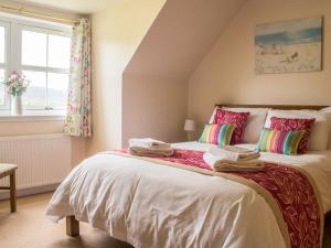 a bedroom with a bed with towels on it at Holiday Home Strath Glebe by Interhome in Broadford