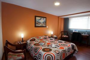 a bedroom with a bed and a table and a window at Hotel Francés La Maison in Pasto