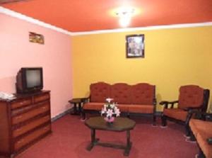 sala de estar con sofás, TV y mesa en Apart Hotel Turquesa en Potosí