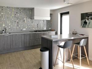 a kitchen with a counter and two bar stools at Holiday Home Oesterdam Resort-1 in Tholen