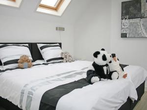 two stuffed animals sitting on top of a bed at Holiday Home Oesterdam Resort by Interhome in Tholen