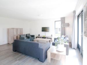 un soggiorno con divano blu e tavolo di Holiday Home Oesterdam Resort-1 a Tholen