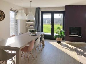 a dining room with a table and chairs and a fireplace at Holiday Home Oesterdam Resort-1 in Tholen