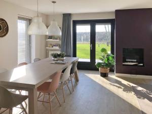 a dining room with a table and chairs and a fireplace at Holiday Home Oesterdam Resort-1 by Interhome in Tholen