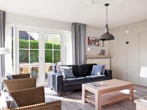 a living room with a couch and a table at Holiday Home Bungalowpark It Wiid by Interhome in Eernewoude