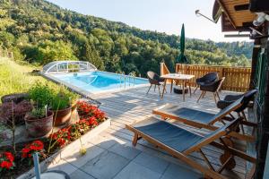 um pátio com uma mesa e cadeiras e uma piscina em Ferienhaus Riegelnegg em Oberhaag