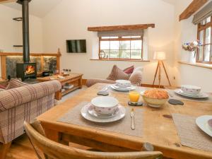 a living room with a wooden table and a fireplace at Little Crake Howe in Grayrigg