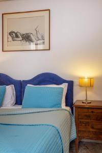 a bedroom with a blue bed and a nightstand with a lamp at Ca degli Angeli in Venice