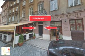 a building with two signs on the side of a street at Дизайнерські апартаменти на вулиці Краківській 17 в центрі Львова in Lviv