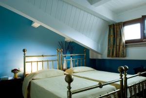 two beds in a bedroom with blue walls and a window at Lo Squero Guest House in Fano +17 photos