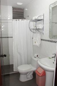bagno bianco con servizi igienici e lavandino di Hotel Mantas Cusco a Cuzco