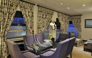 a living room with a glass table and purple chairs at The Portswood Hotel in Cape Town