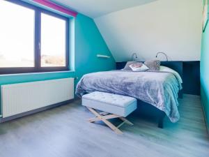 Dormitorio azul con cama y banco en Luxurious Villa in Durbuy with Swimming Pool, en Durbuy