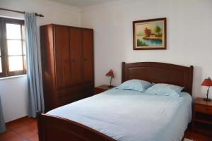 ヴィラ・ノヴァ・デ・ミルフォンテスにあるApartamentos Cintra do Valeのベッドルーム1室(白いシーツ付きのベッド1台、窓付)