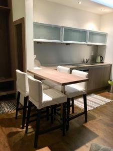 cocina con mesa de madera y sillas blancas en Triangel 215 en Donovaly