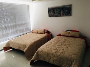 a bedroom with two beds and a window at Estadía El Dorado in Bogotá +10 photos