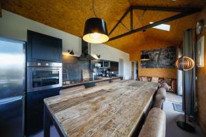 ヴィレルヴィルにあるCottages Domaine du Grand Becのキッチン(大きな木製テーブル付)