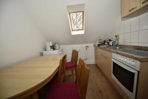 a kitchen with a wooden table and a counter top at Ferienwohnung Villa Weyermann in Leichlingen