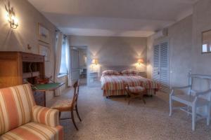 een slaapkamer met een bed en een tafel en stoelen bij Marchesi Alfieri - Cantine e Ospitalità in San Martino Alfieri