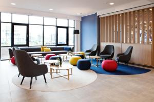 a waiting room with chairs and tables and windows at Holiday Inn Express - Sindelfingen, an IHG Hotel in Sindelfingen