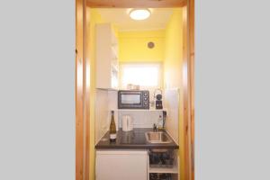 a small kitchen with a sink and a microwave at SO APARTMENTS am Marktplatz 2 in Weinheim
