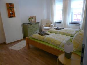 1 dormitorio con 2 camas, vestidor y silla en Ferienwohnung Bernhard, en Bad Camberg