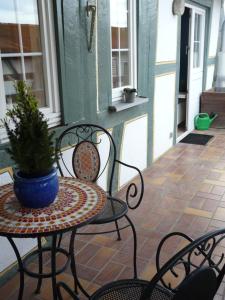 um pátio com duas cadeiras e uma mesa com um vaso de plantas em Ferienwohnung Bernhard em Bad Camberg